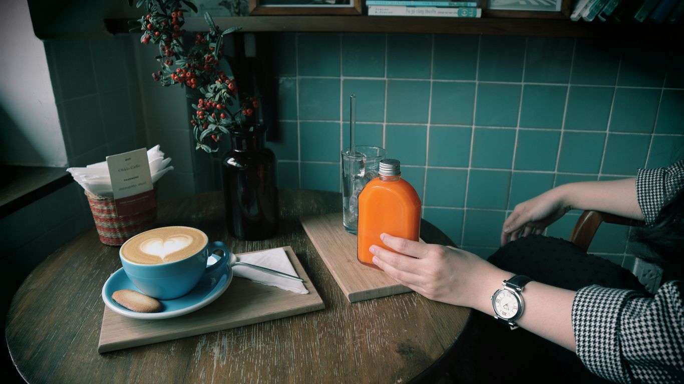 person holding orange plastic bottle