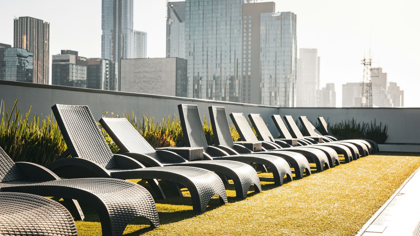 Lounge chairs overlook a city skyline.