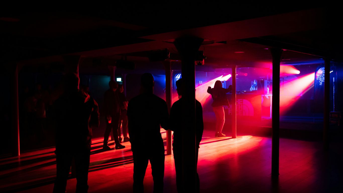 a group of people standing in a room with a red light