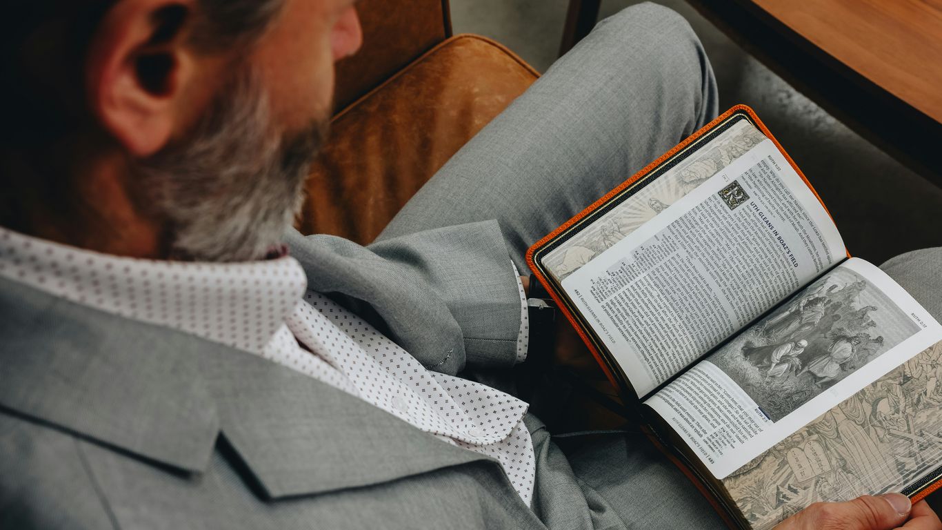 A man sitting in a chair reading a book