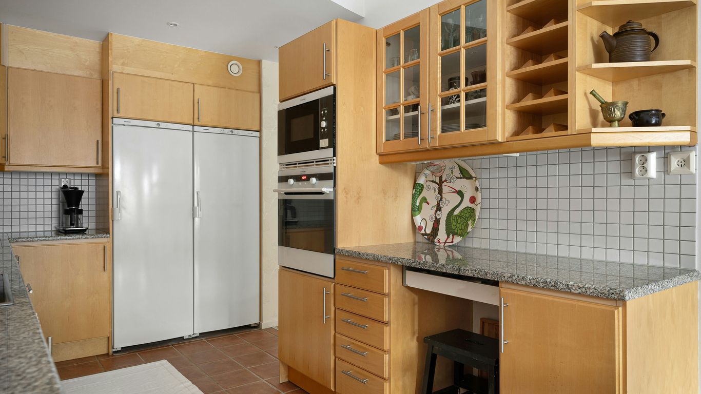 A kitchen with wooden cabinets and white appliances