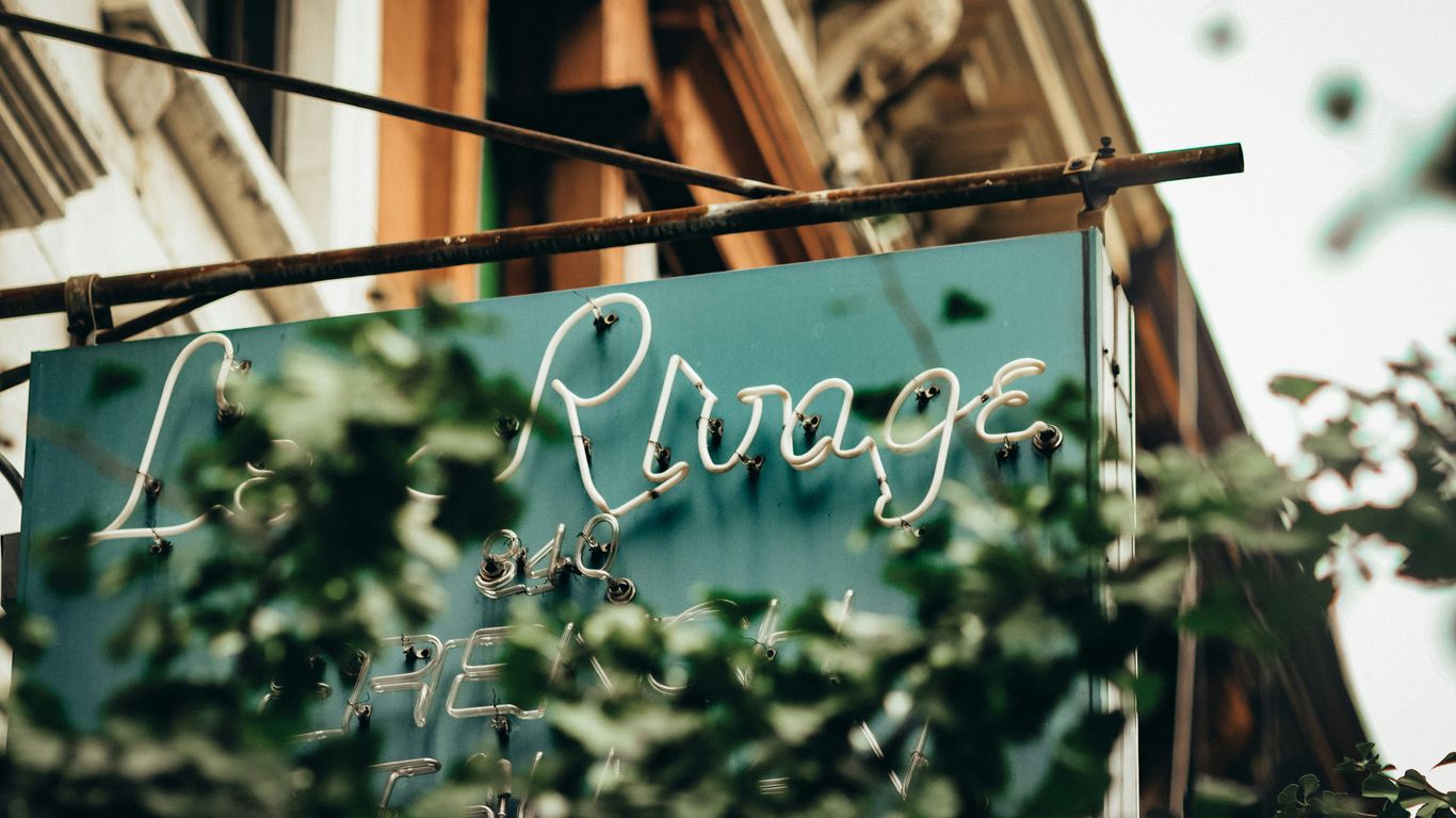a blue sign hanging from the side of a building