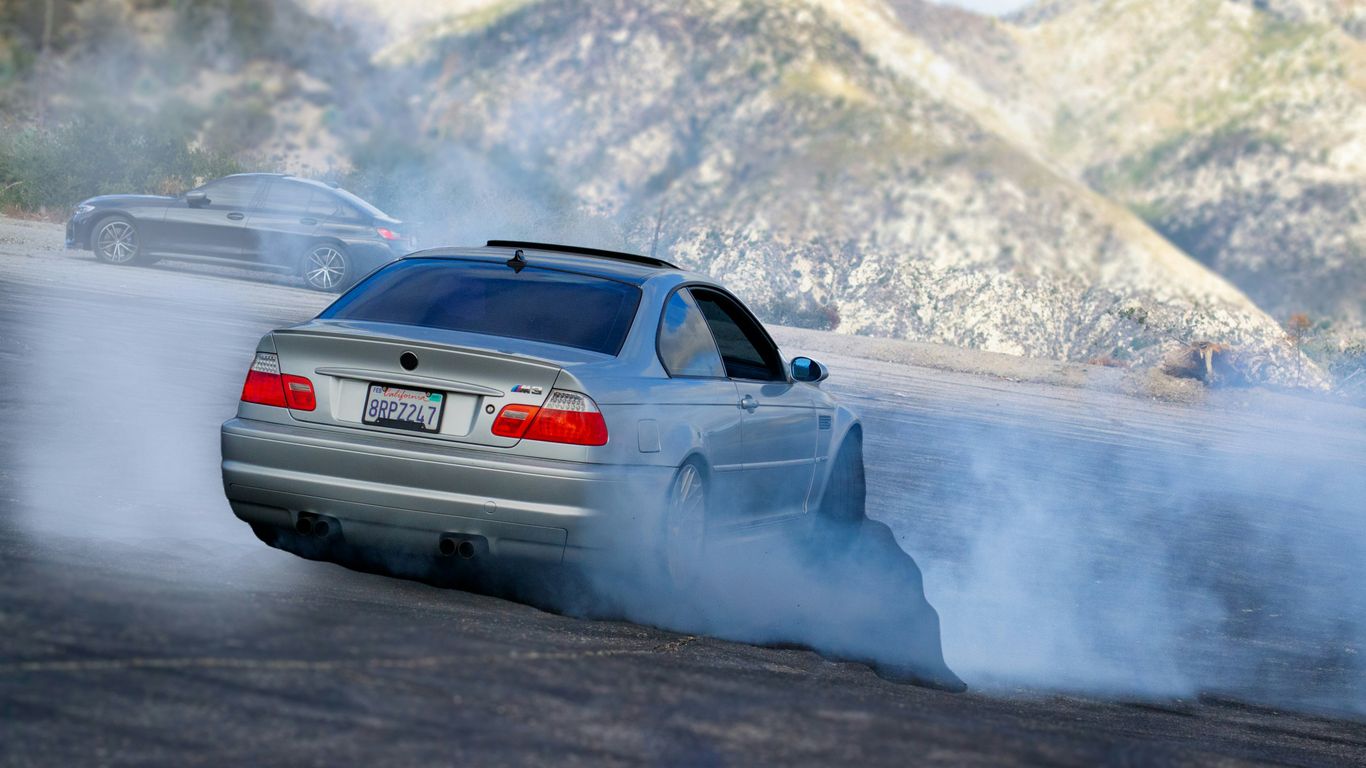 a car driving on a road with smoke coming out of it