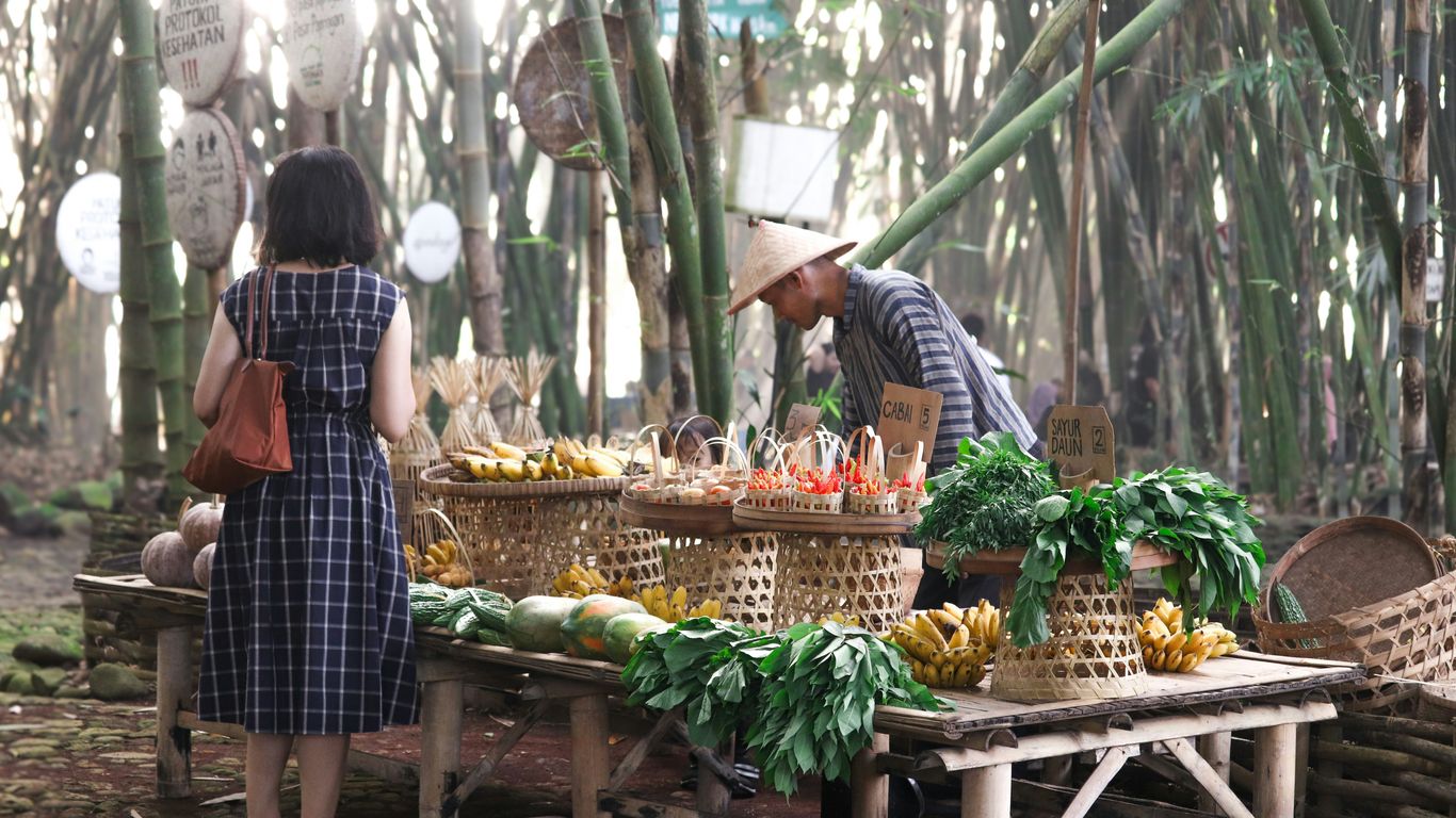 A man and a woman standing in front of a table filled with fruits and vegetables