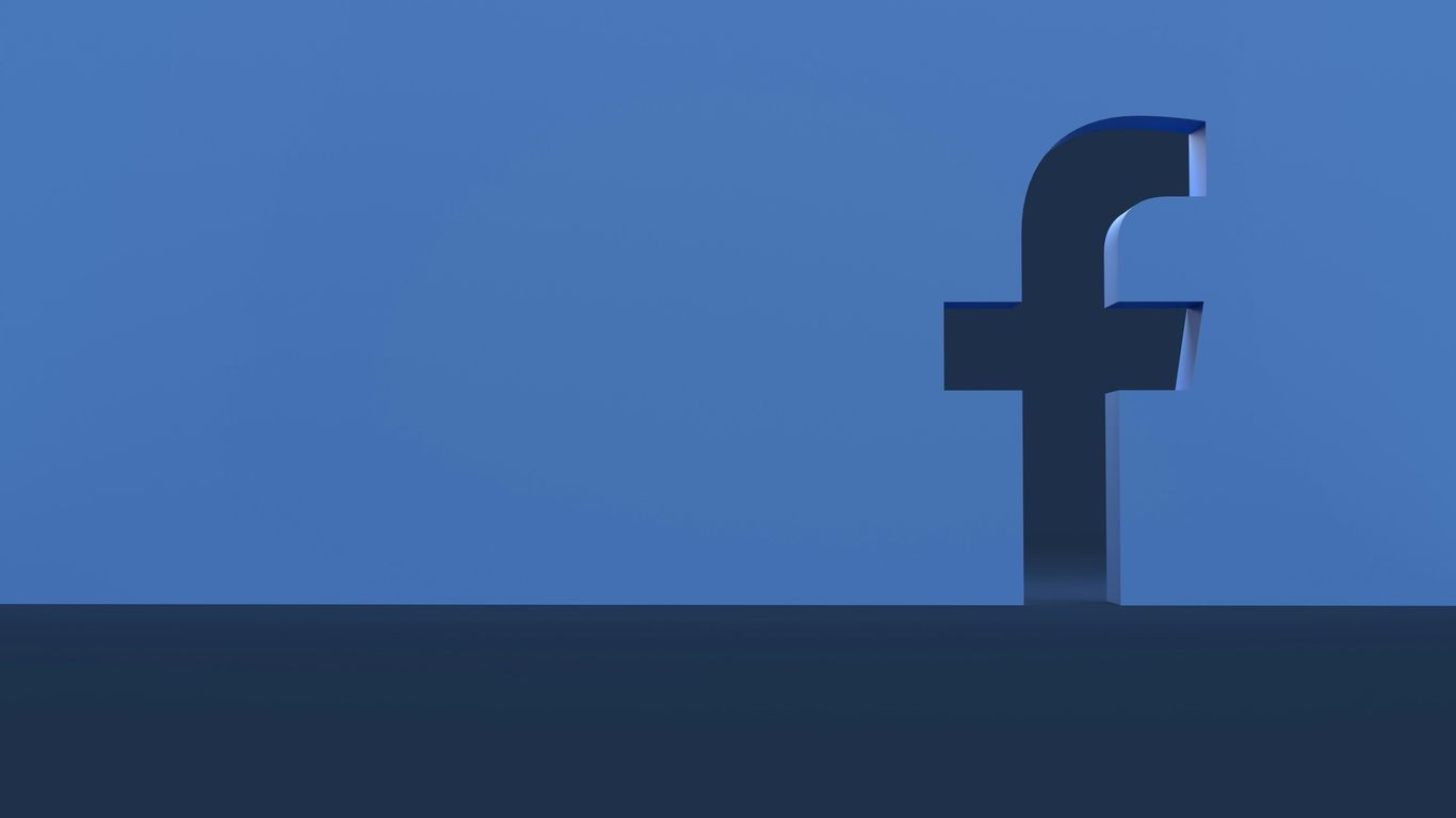 a person standing in front of a facebook logo