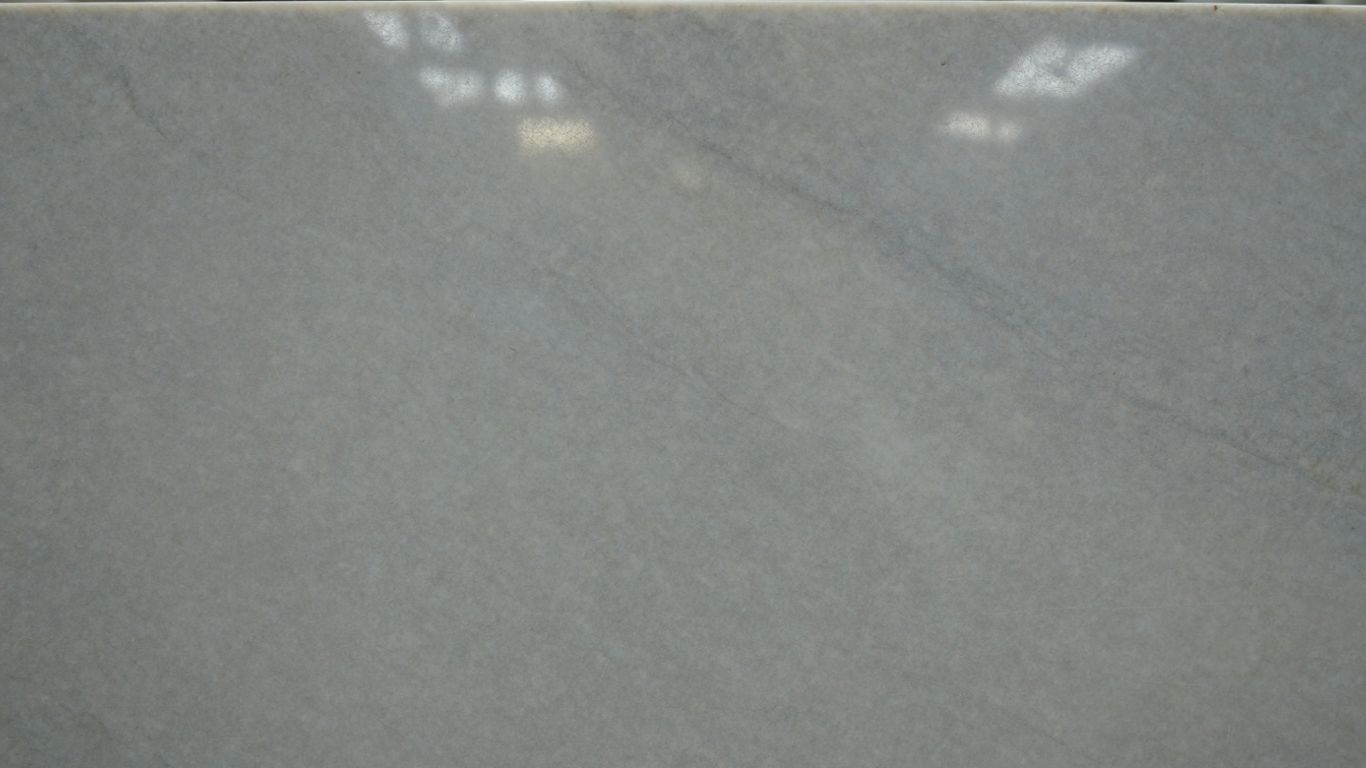 Polished white Thassos marble slab with subtle veining.