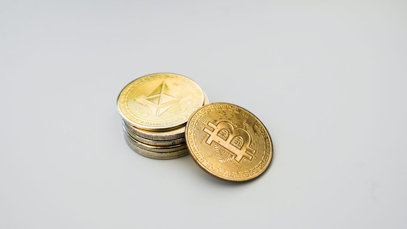 Stack of cryptocurrency coins, including Bitcoin and Ethereum.
