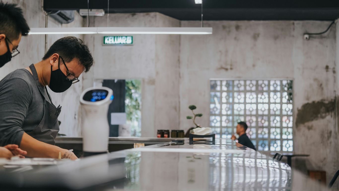 man in black framed eyeglasses sitting by the table