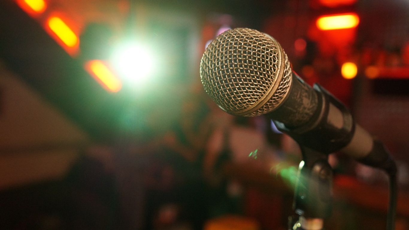A microphone in a vibrant, illuminated venue setting.