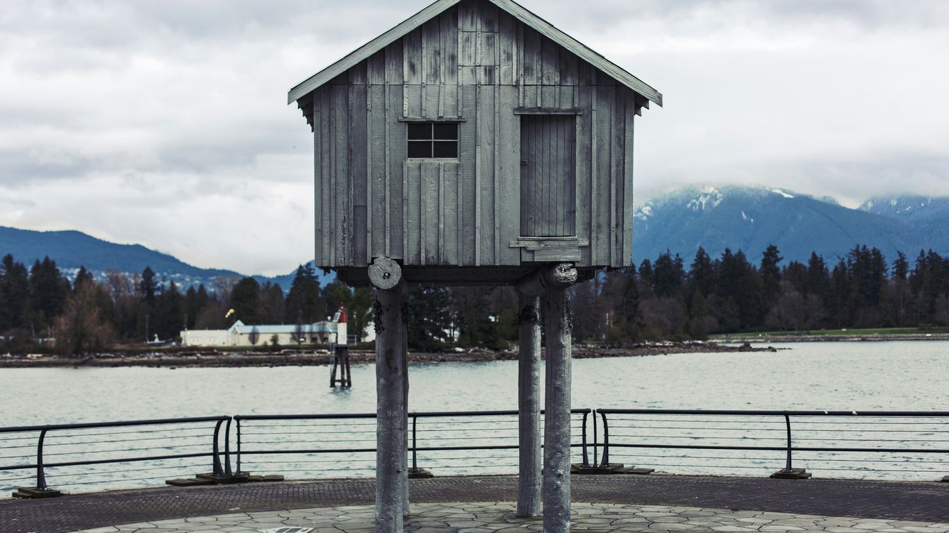 shallow focus photo of gray shed near body of water