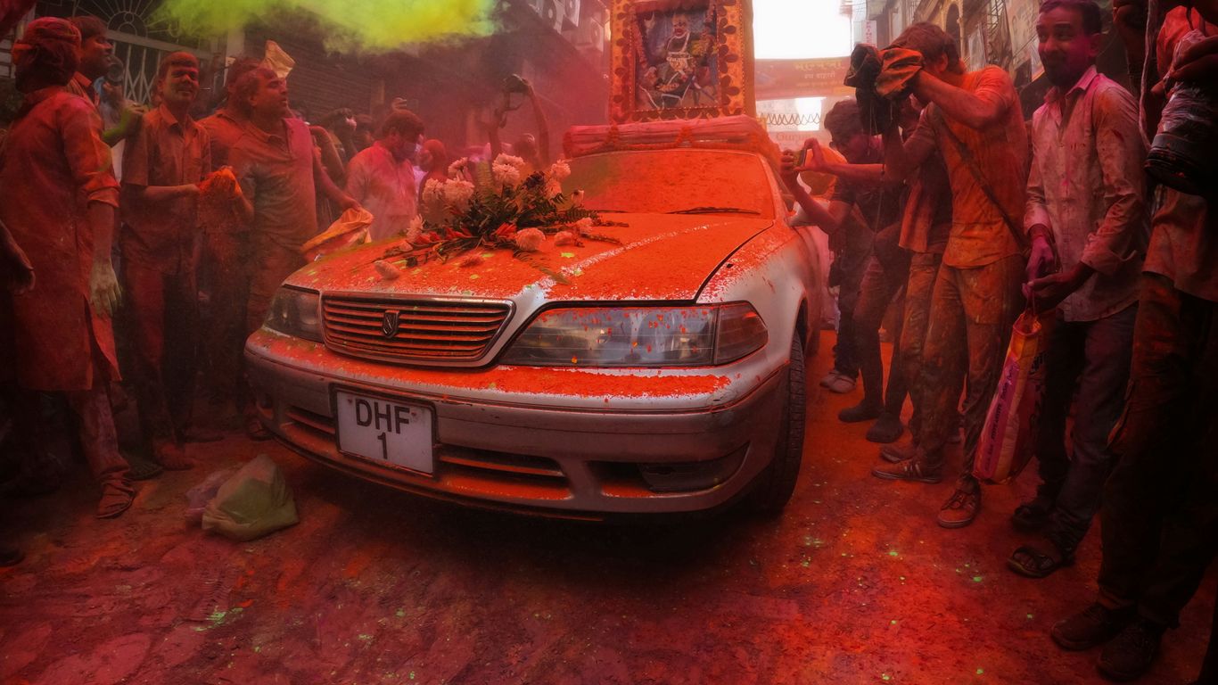 a group of people standing around a burnt car