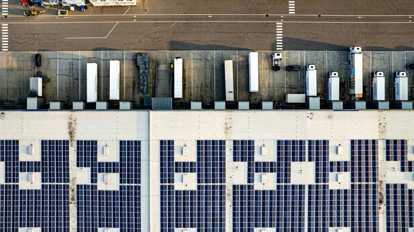 An aerial view of a parking lot with lots of solar panels