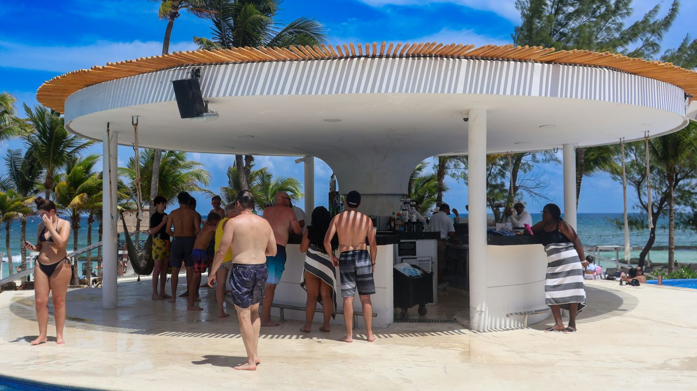 A group of people standing around a swimming pool