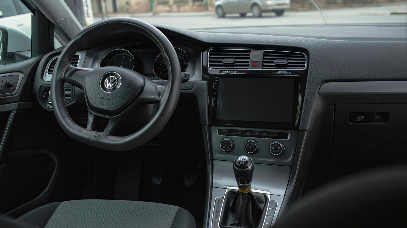 the interior of a car with a steering wheel and dashboard