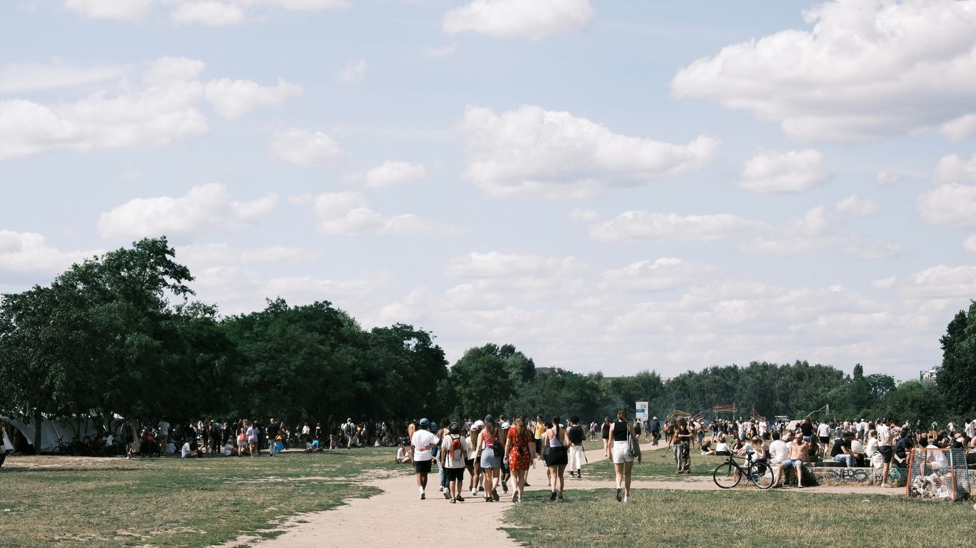 A group of people standing on top of a grass covered field
