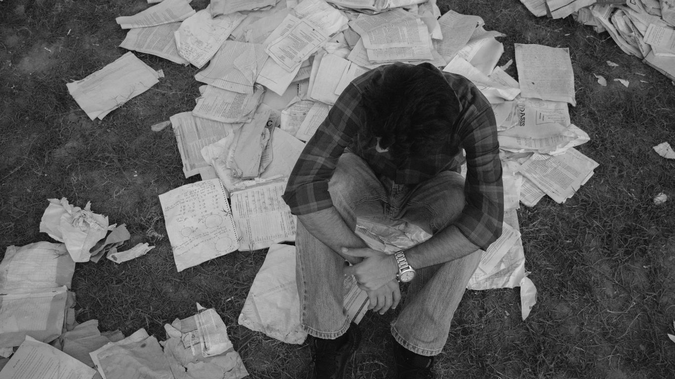 a man sitting on top of a pile of papers