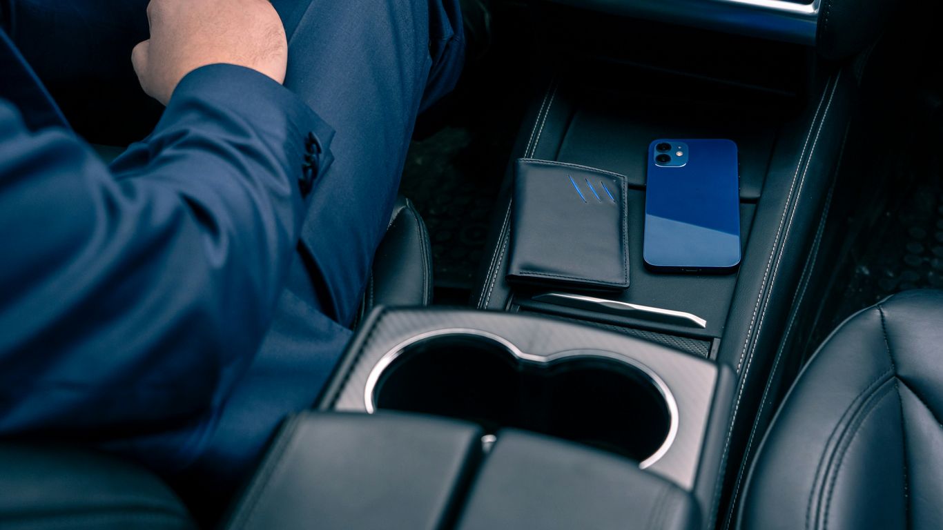 a man sitting in a car holding a cell phone