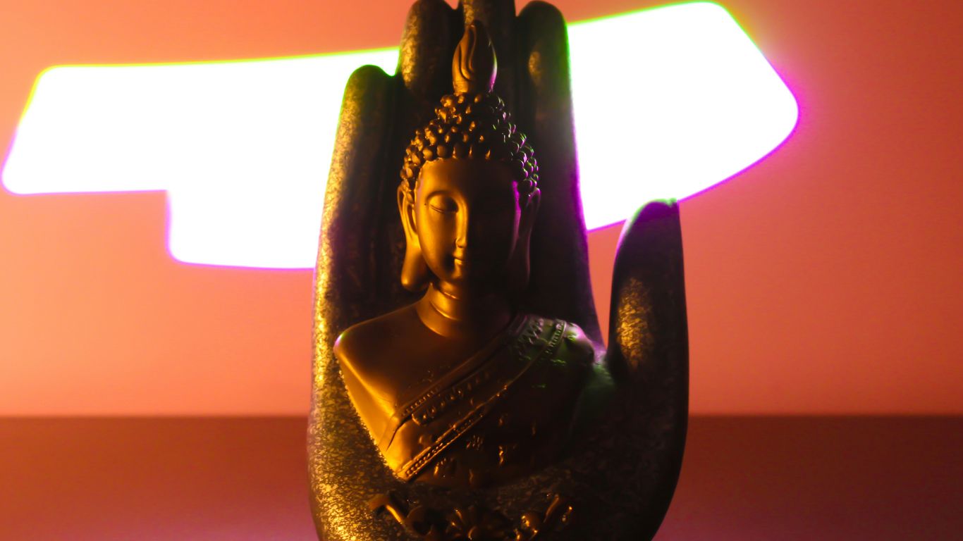 gold buddha figurine on purple table