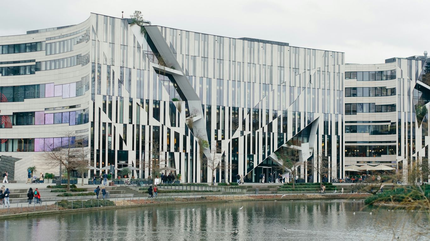 Modern architecture with interesting design by a lake.