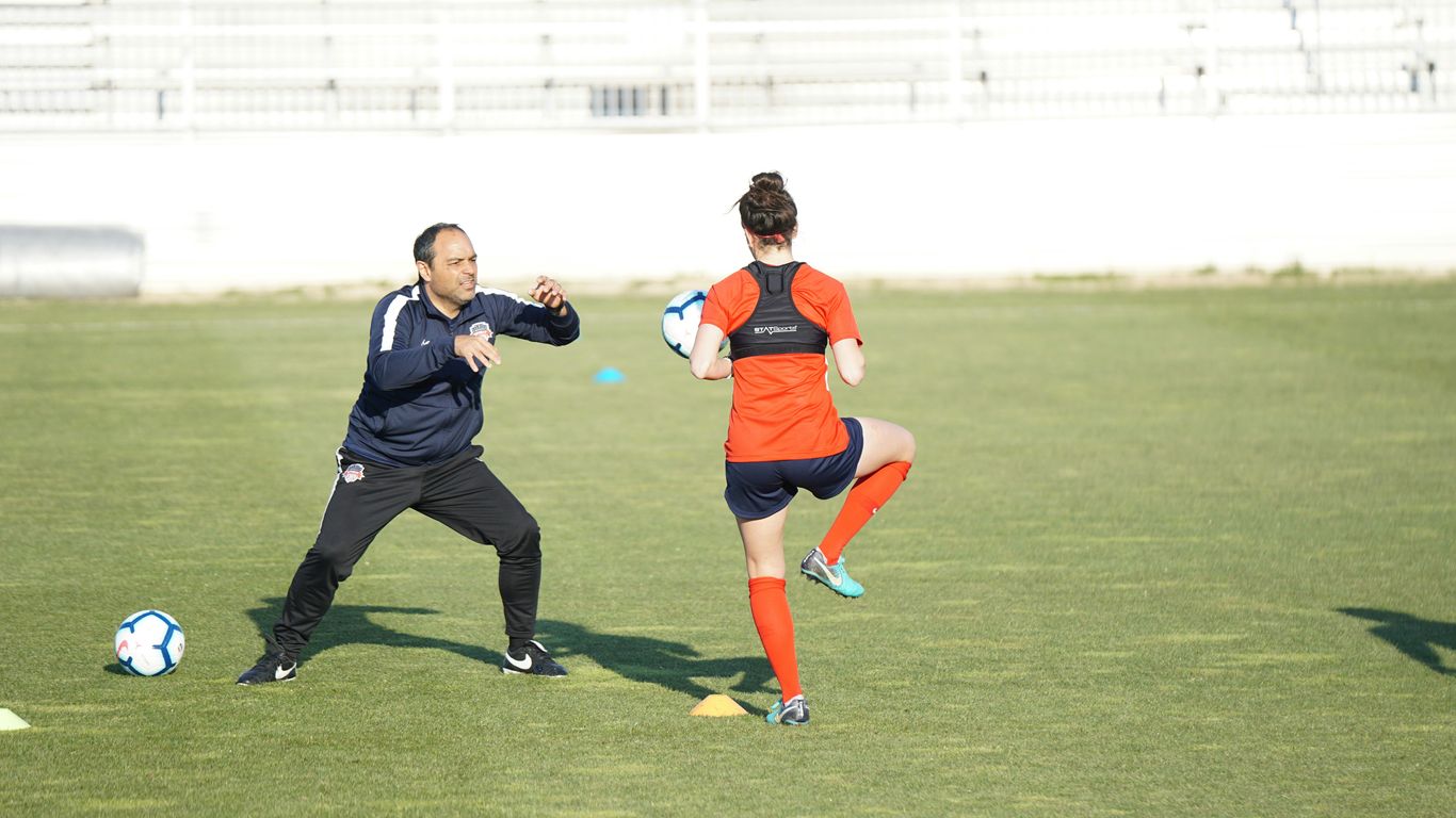 a couple of people on a field with a soccer ball
