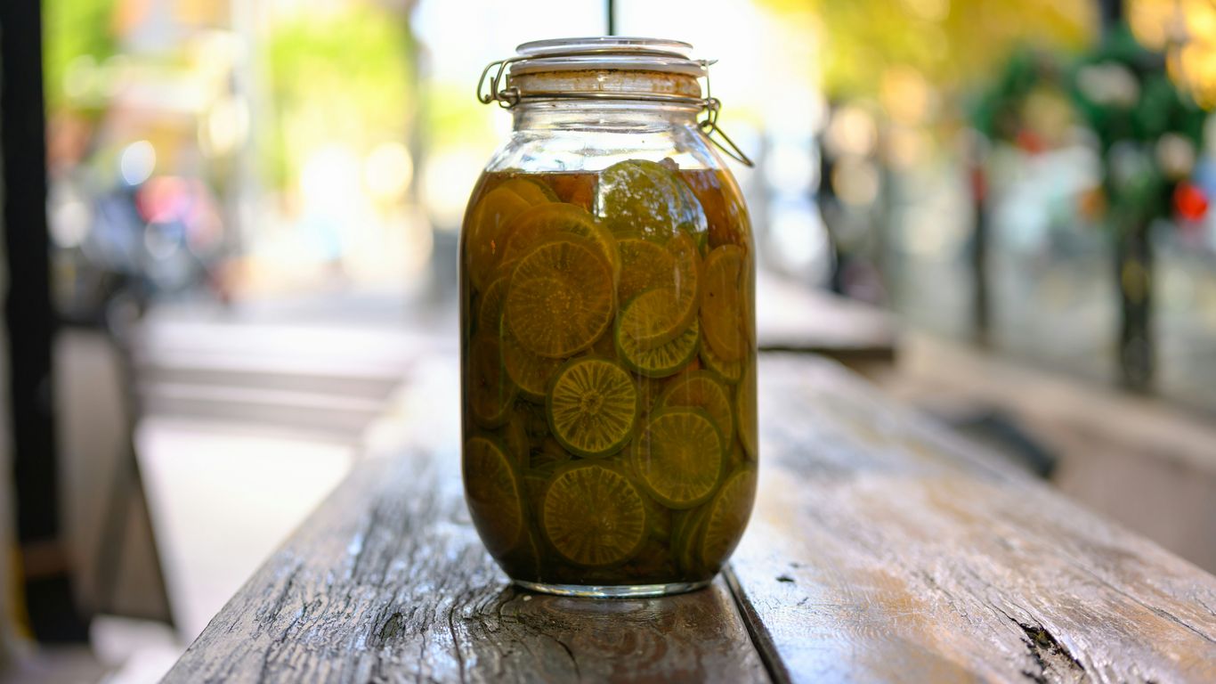 A jar of pickles sitting on top of a wooden table