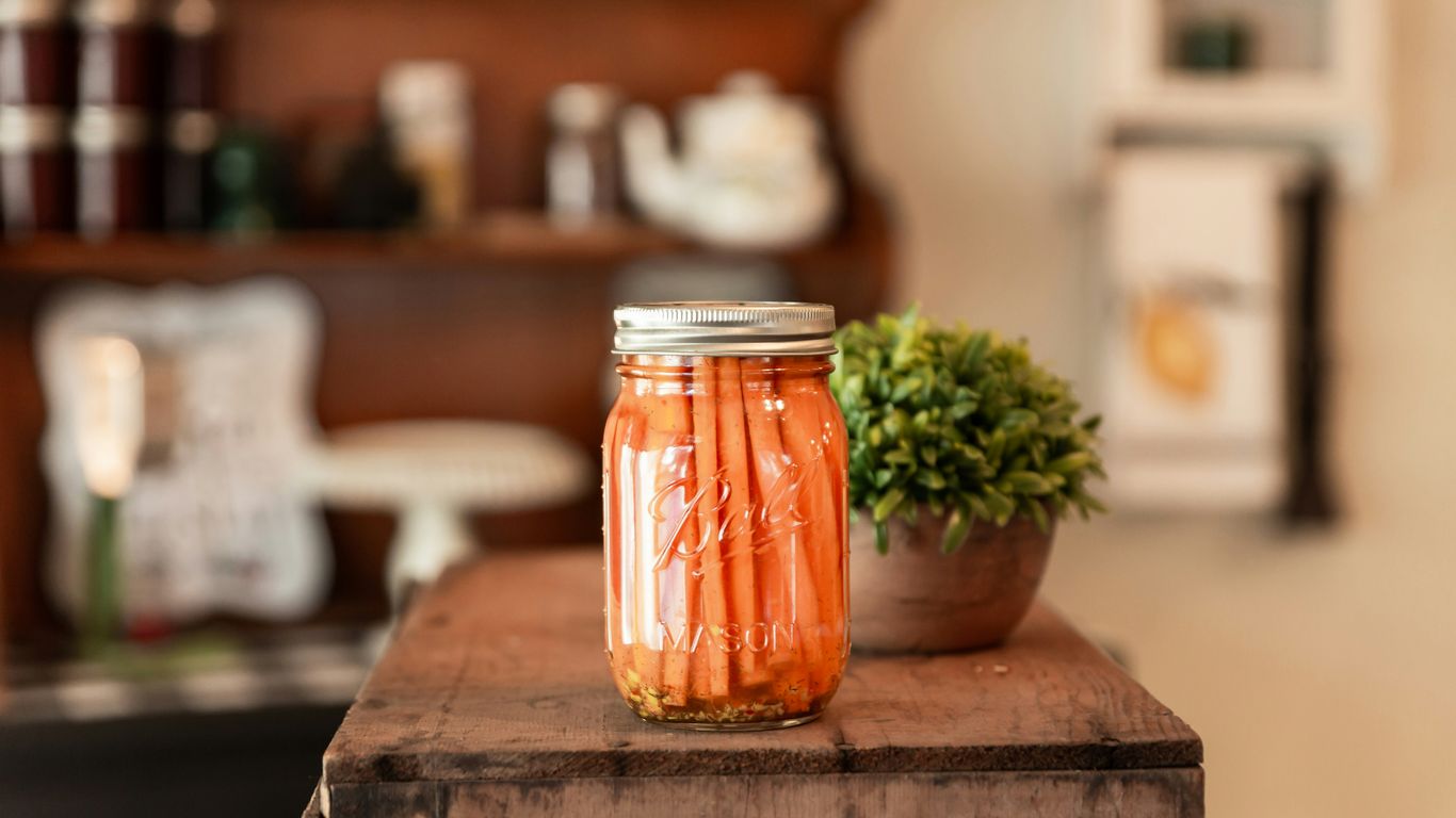 a jar of pickled carrots sitting on a table