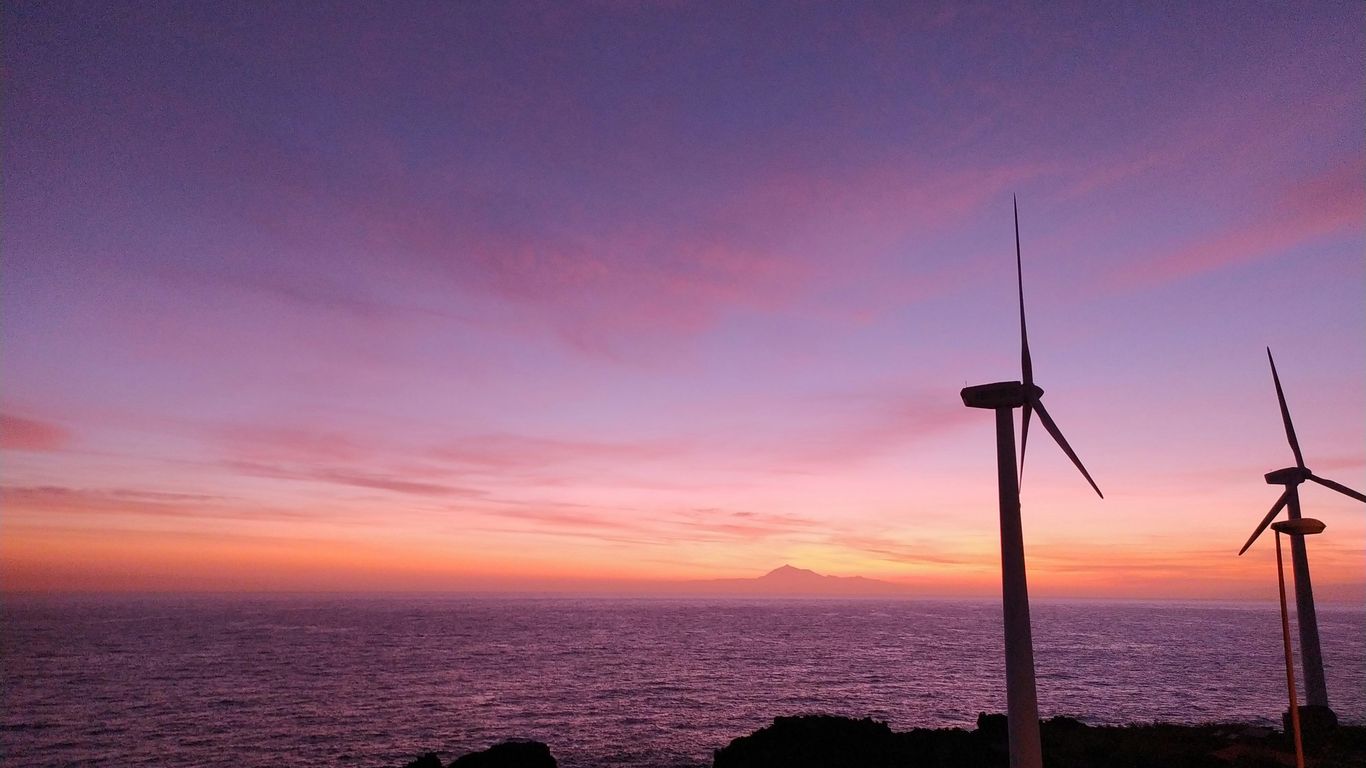 a couple of windmills that are by the water