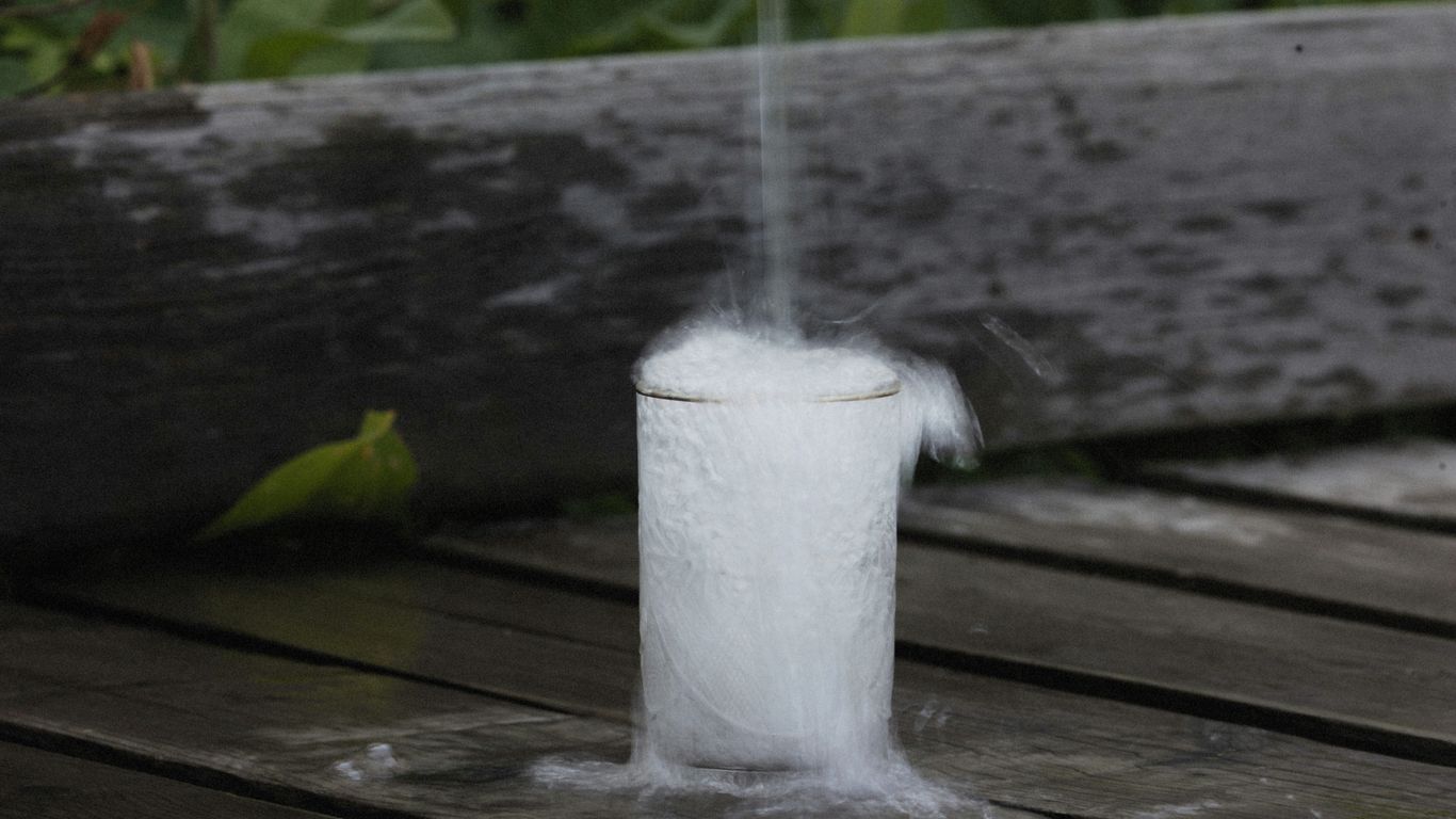 a white cup with a small amount of smoke coming out of it