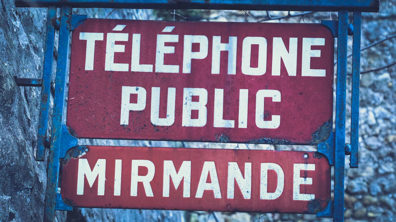 a red sign that says telephone public and mermaide