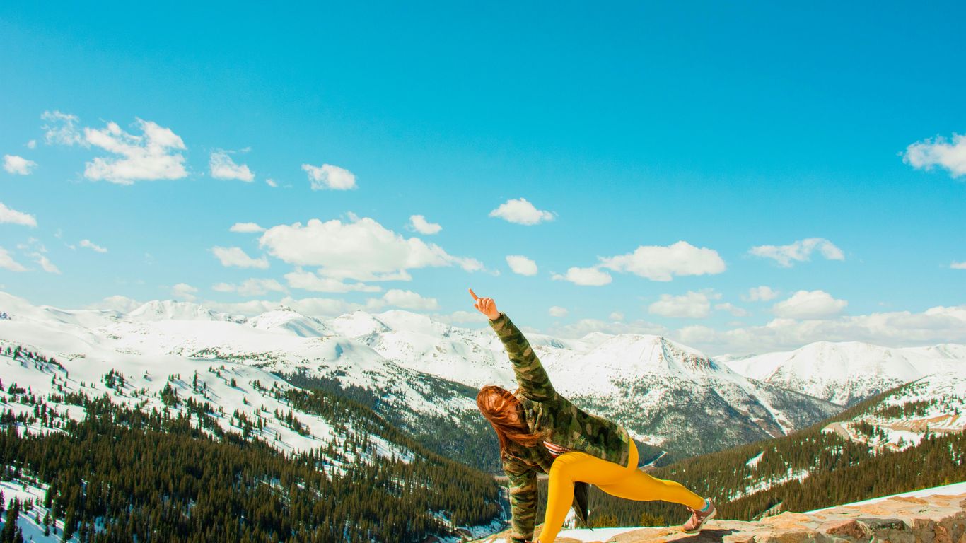 woman performing yoga on cliff