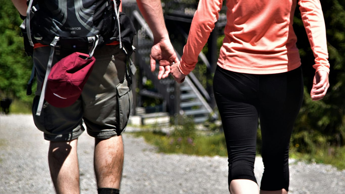 2 men in red shirt and black shorts running on road during daytime