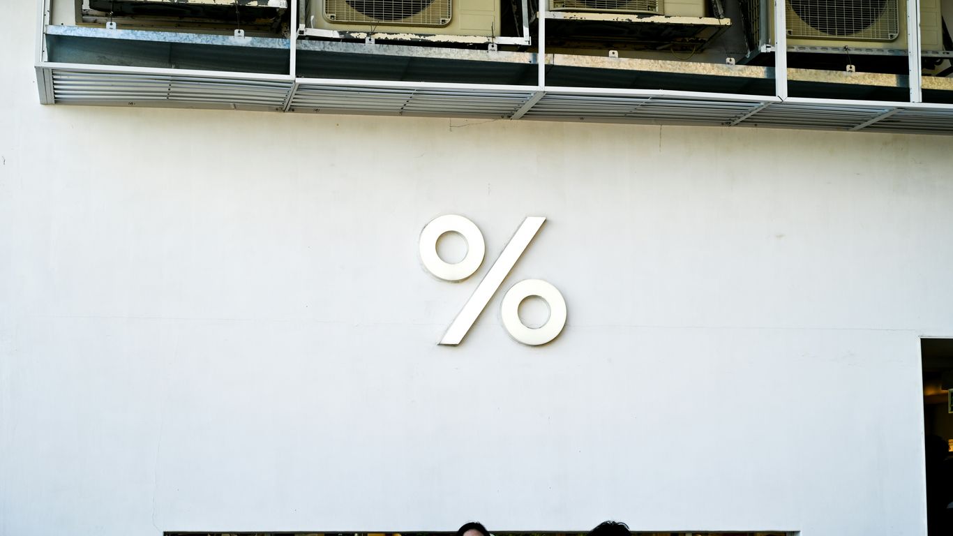 White wall with a large percent sign logo