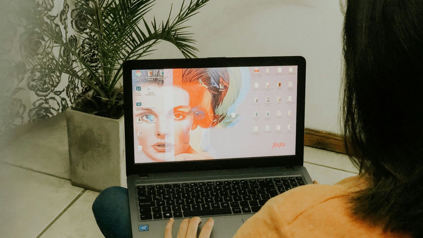 woman in yellow long sleeve shirt using macbook pro