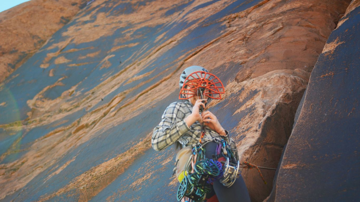 A woman standing on top of a rock next to a mountain