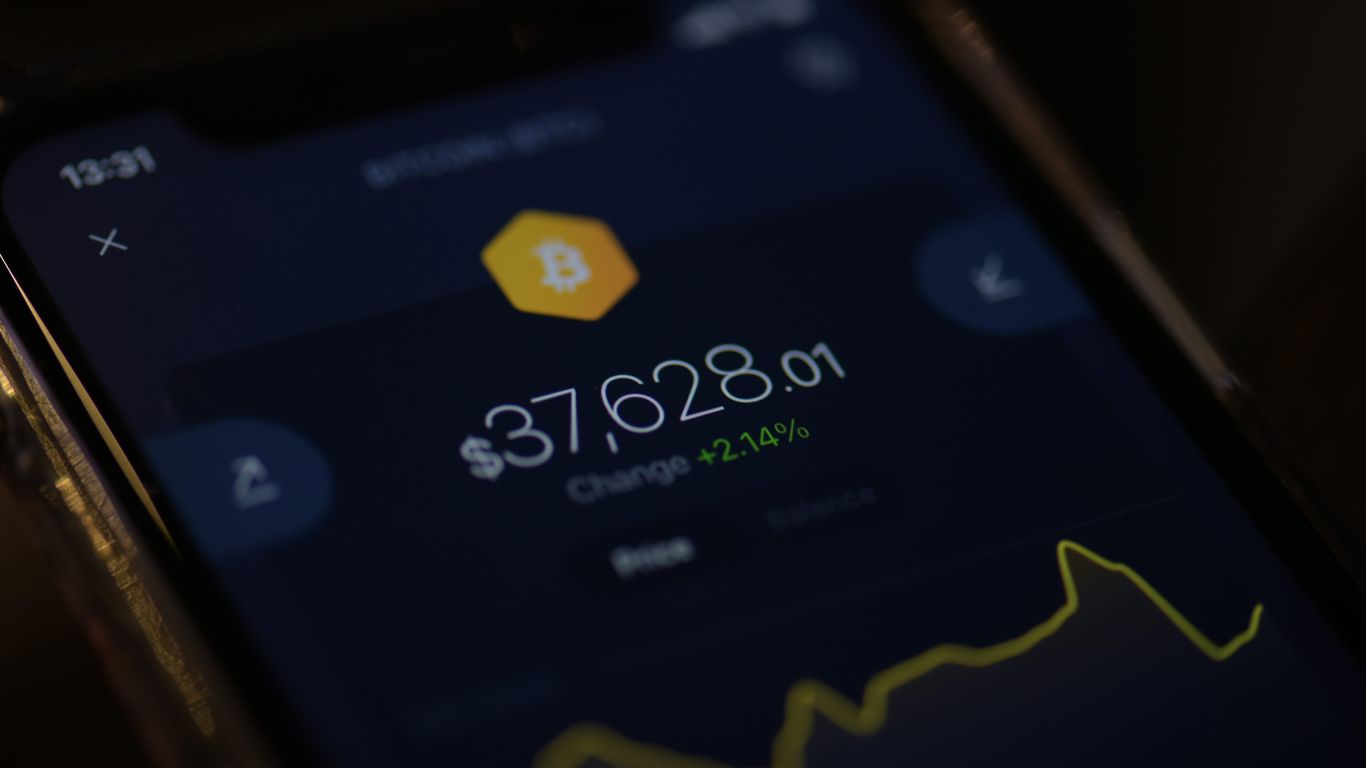A smartphone displaying a Bitcoin price and change percentage.
