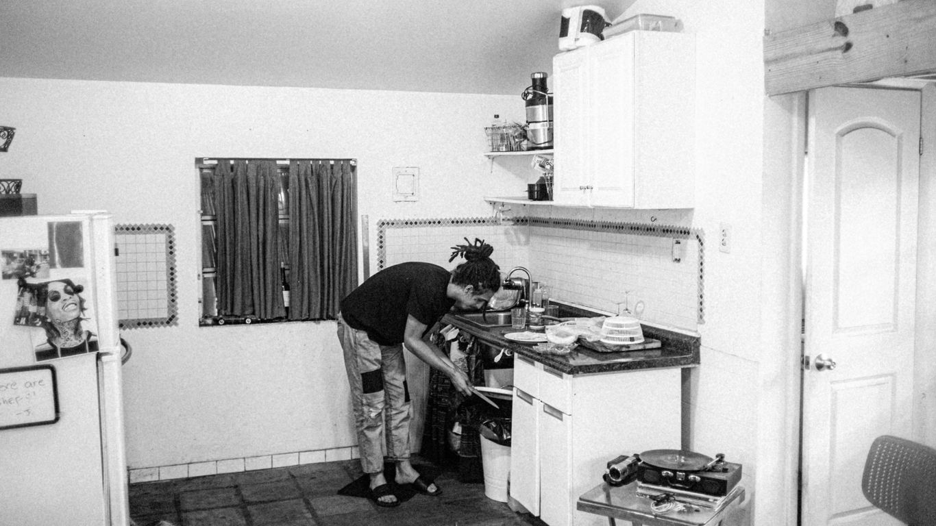 a black and white photo of a man in a kitchen