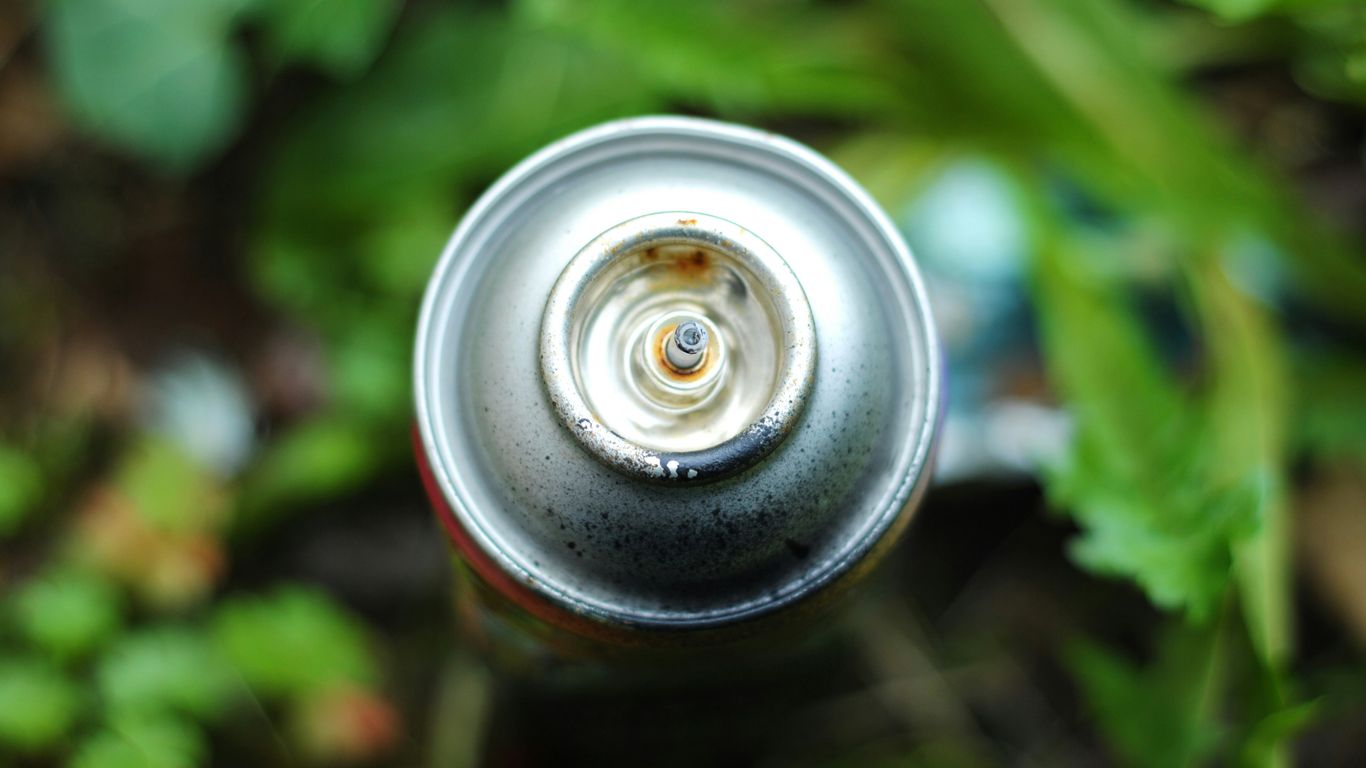 gray spray can near green plants