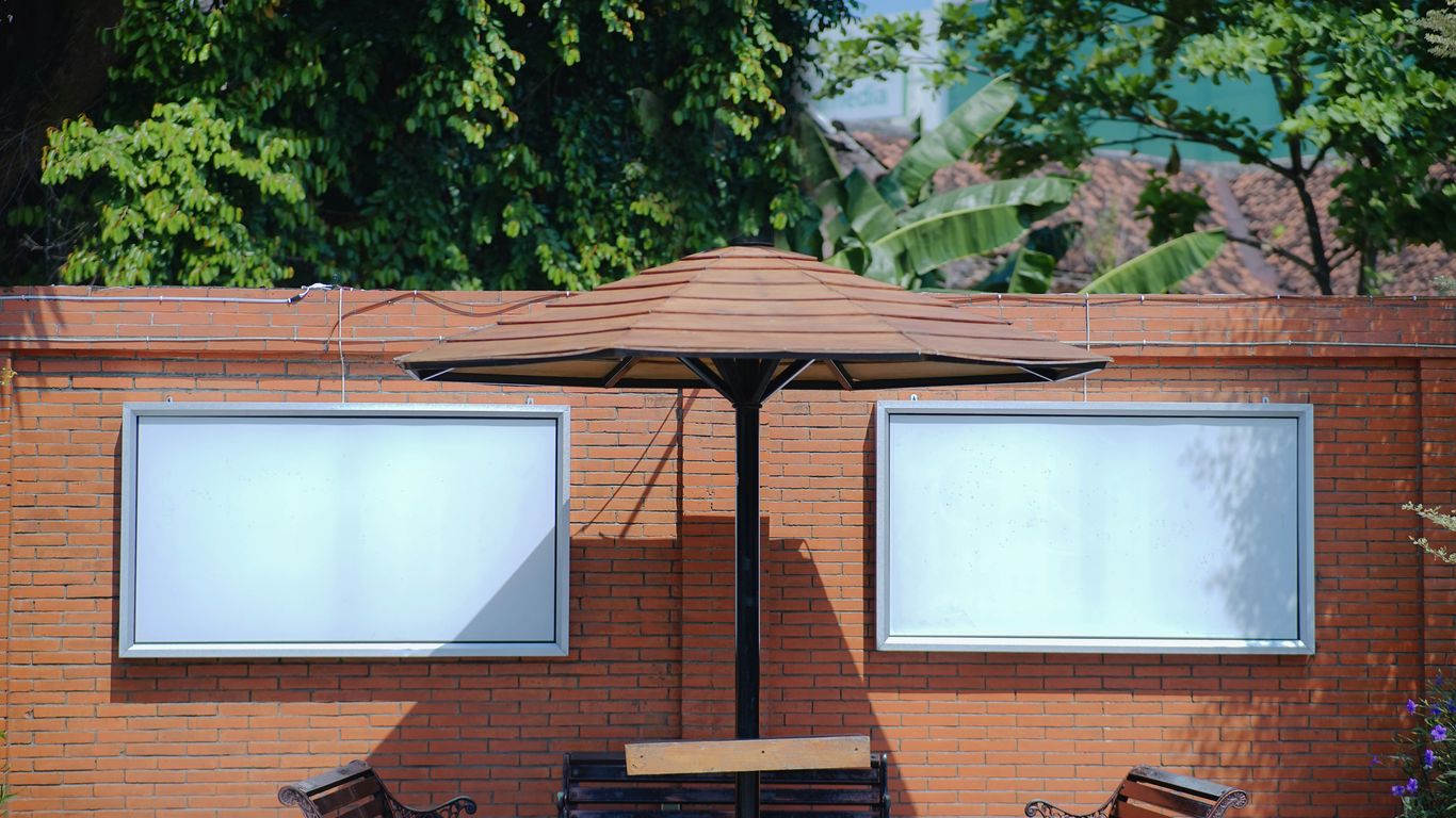 A couple of benches sitting under an umbrella