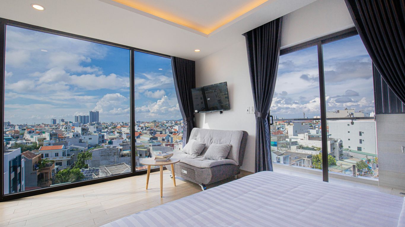 a room with a large window and a couch and a table with a tv and a view of