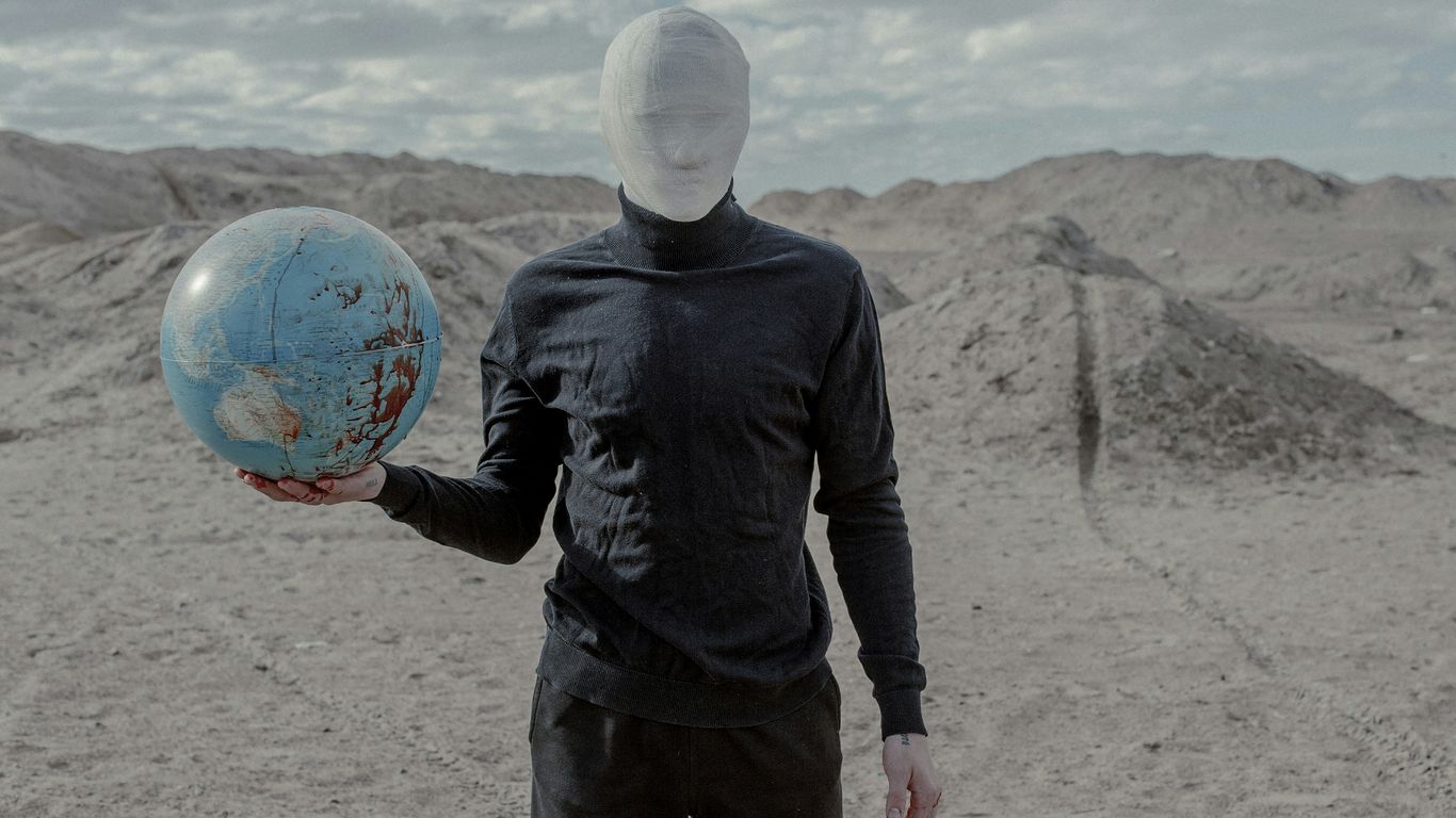 a man in a black shirt holding a blue ball