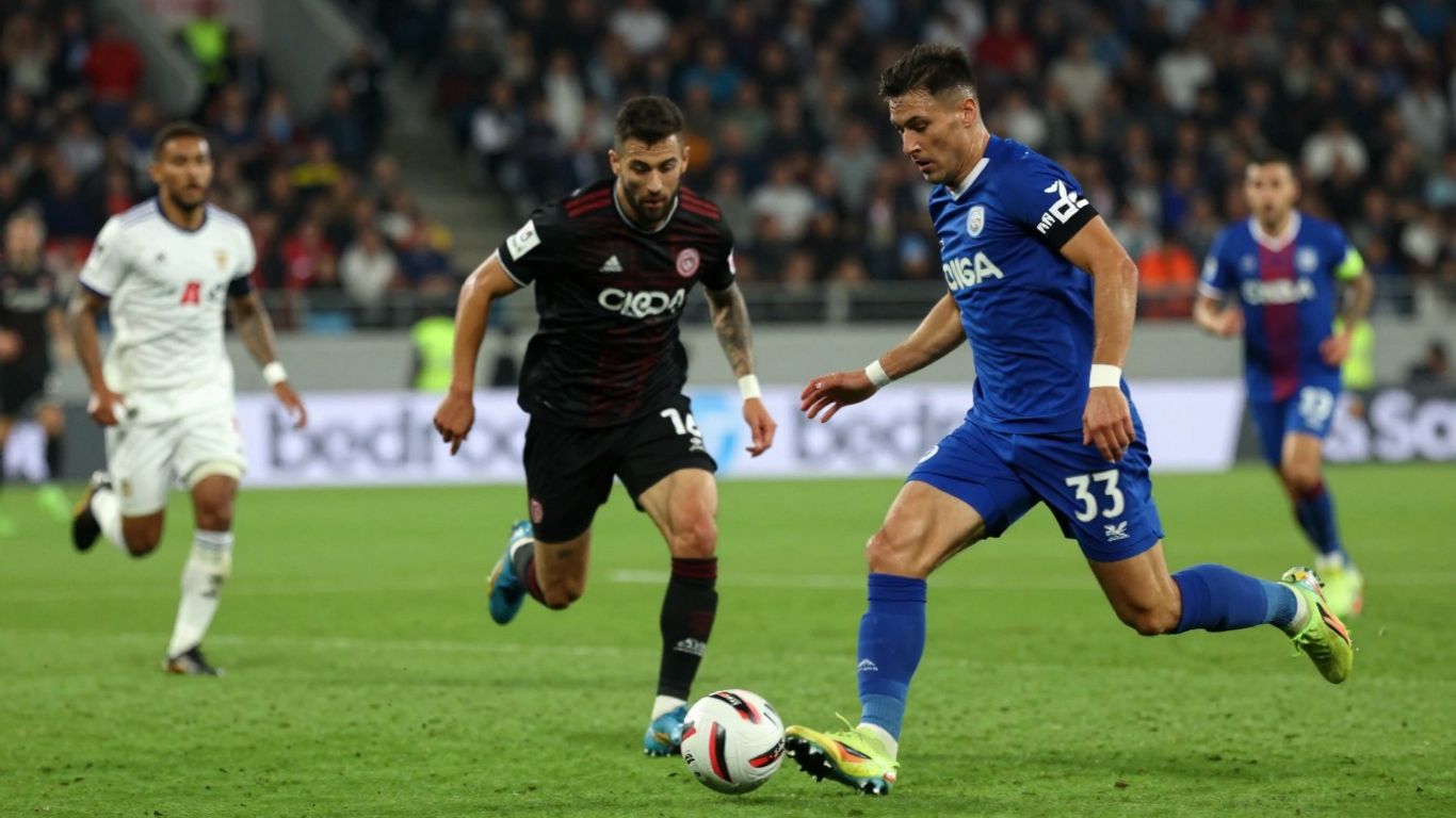 Live football match action with blurred crowd in background.