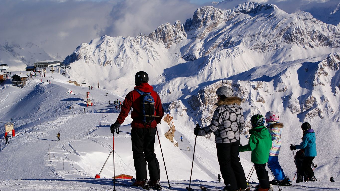 a group of people riding skis on top of a snow covered slope