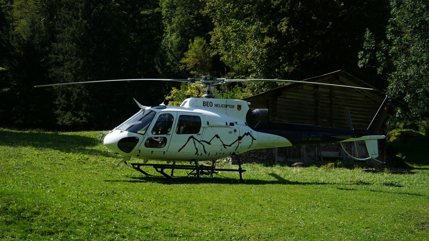a helicopter sitting on top of a lush green field