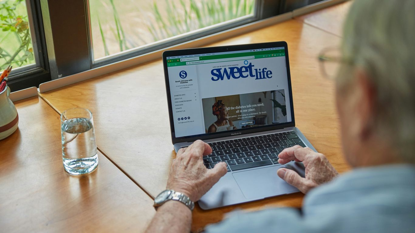 a man sitting at a table using a laptop computer