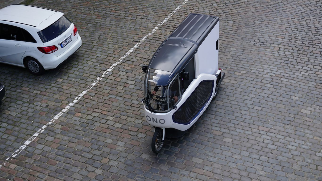 a small white vehicle parked next to a white car