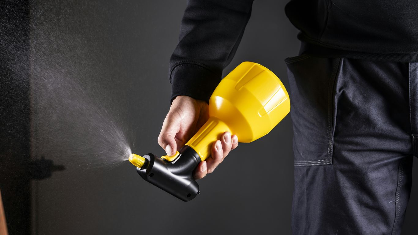 A person is holding a spray gun.