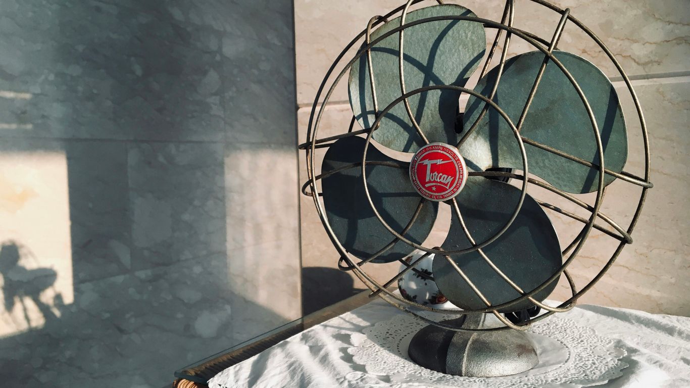 black desk fan on white and black floral table cloth