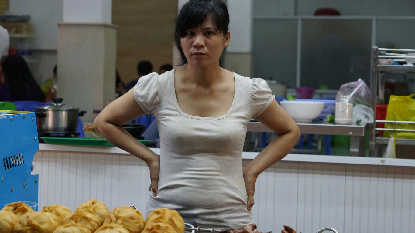 woman in white scoop neck shirt standing in front of baked bread
