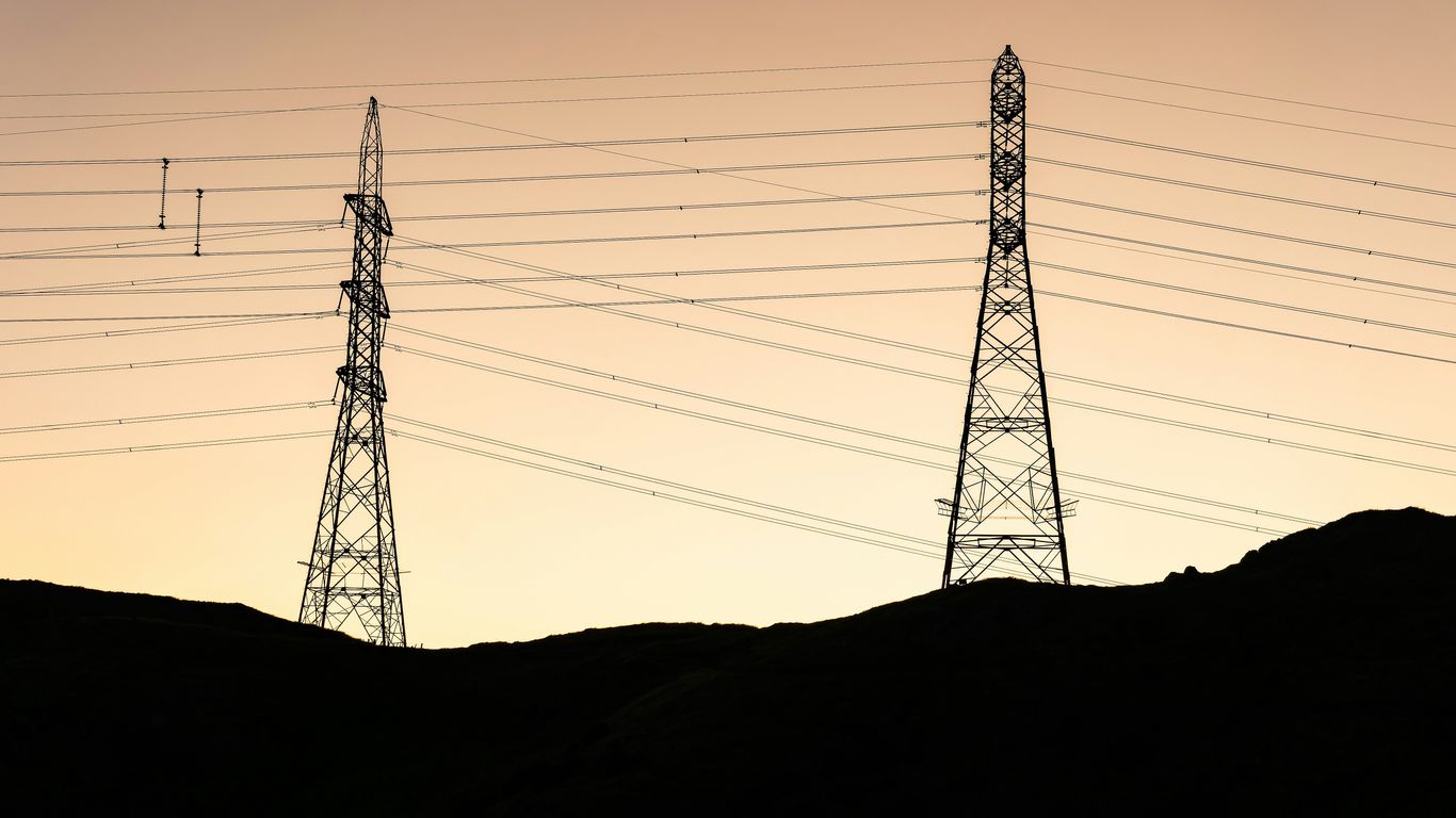 Two tall power line towers against a pale sky.