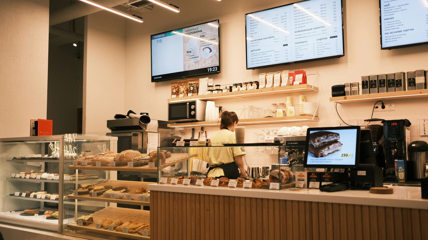 a woman behind the counter of a bakery